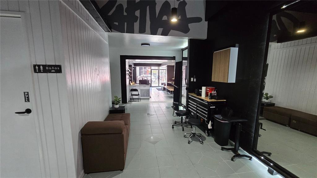 A modern studio space features white paneled walls, tiled floors, and a large wall mirror — 156 CALLE JOSE DE DIEGO, CAYEY, PR