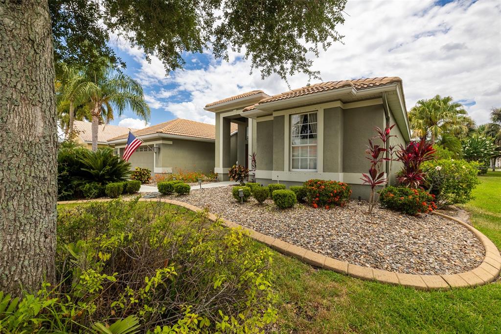A single-story house with a tan stucco exterior, tile roof, and a rock-covered front yard — 6171 PALOMINO CIRCLE, BRADENTON, FL