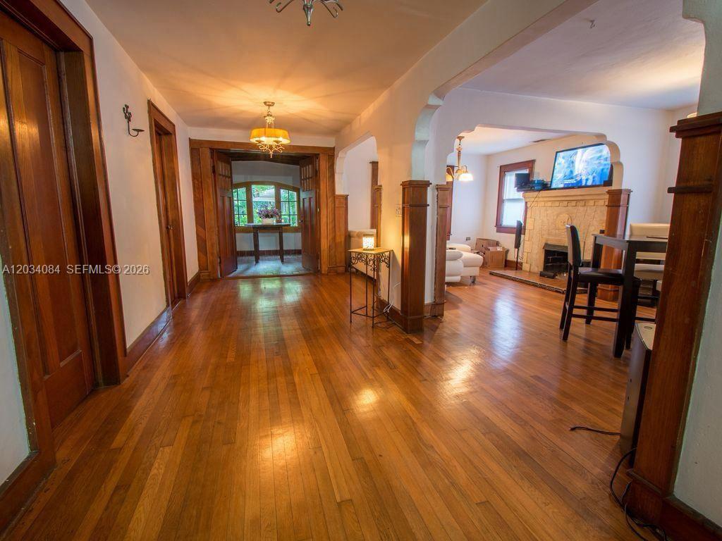 A screened-in porch overlooks a wooded backyard with dense trees and foliage — 8238 NE 9th Ave, Miami FL 33138, MIAMI, FL