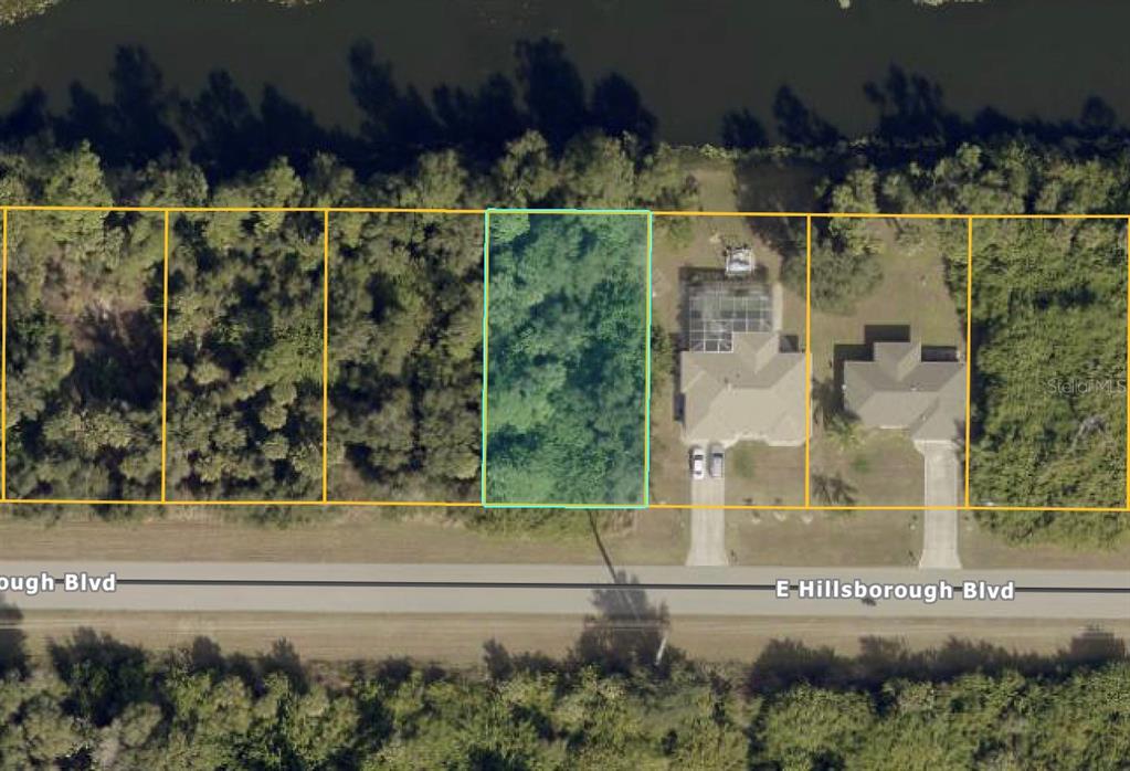 This aerial map shows a vacant, rectangular lot highlighted in blue along a road — Lot 19 E HILLSBOROUGH BLVD, NORTH PORT, FL