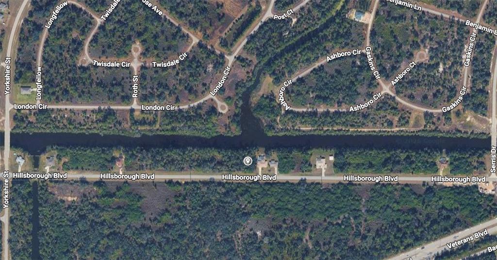 This is an aerial map view of a residential neighborhood with a canal — Lot 19 E HILLSBOROUGH BLVD, NORTH PORT, FL