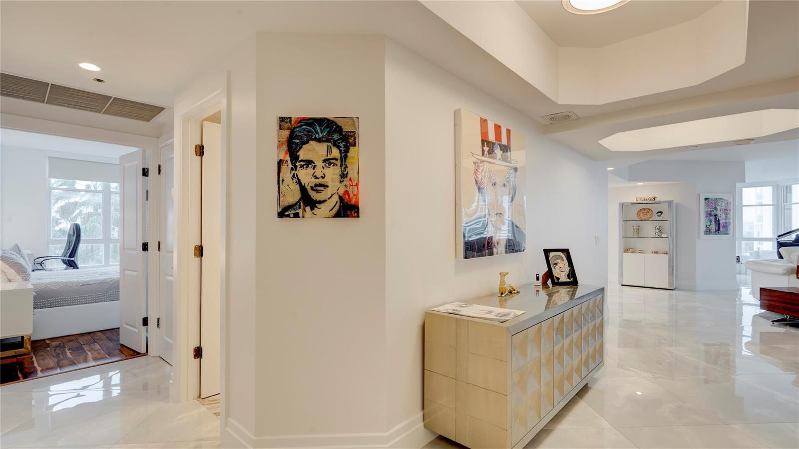 A bright hallway with white tile floors, a textured console table, and wall art — 1440 S Ocean Boulevard # c, Pompano Beach FL 33062, POMPANO BEACH, FL