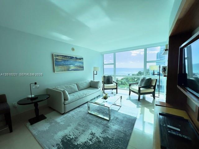 A living room features a sofa, two armchairs, a glass coffee table, and ocean views — 6801 Collins Ave, Miami Beach FL 33141, MIAMI BEACH, FL