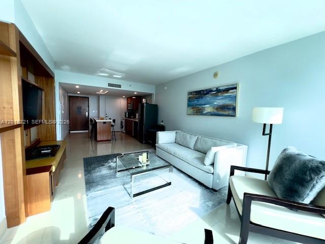 A living room features a white sofa, a glass coffee table, and an armchair — 6801 Collins Ave, Miami Beach FL 33141, MIAMI BEACH, FL
