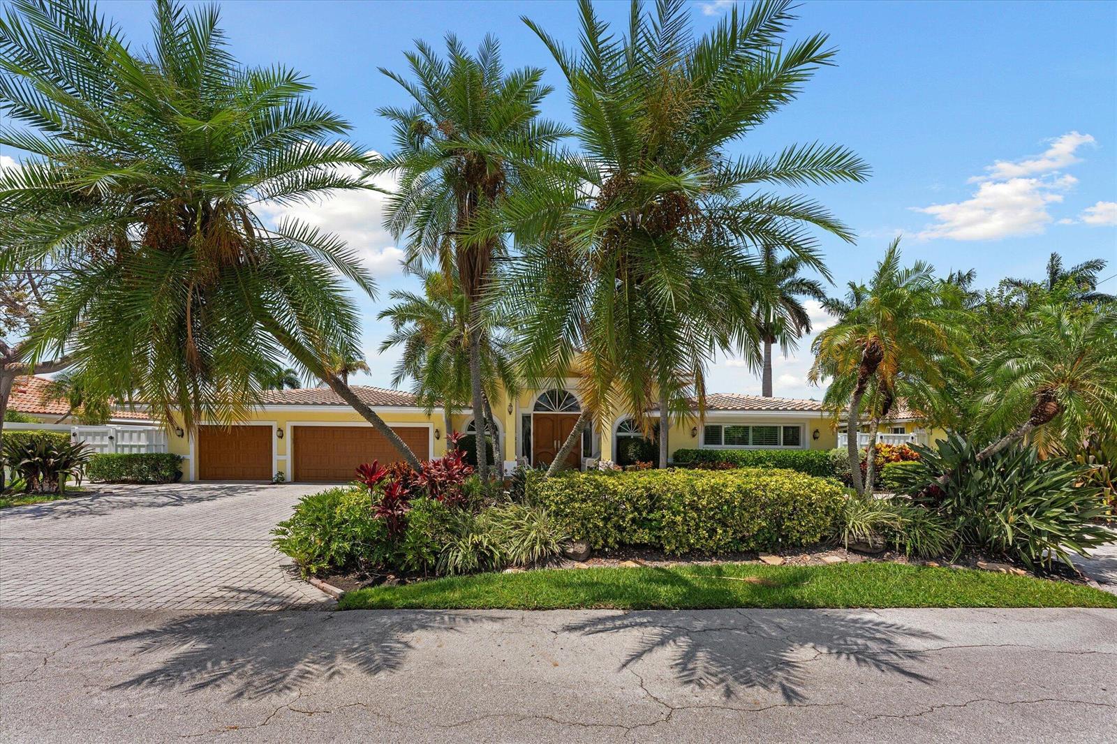 A yellow single-story house with a paved driveway, garage, and palm trees in the front — 2141 NE 29th Street, Lighthouse Point FL 33064, LIGHTHOUSE POINT, FL