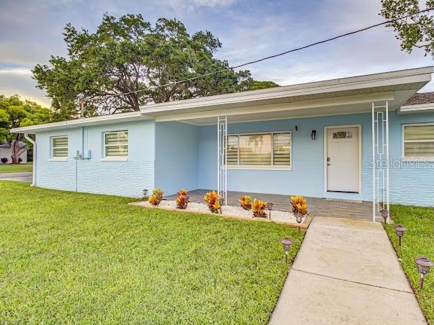 A light blue single-story house features a covered front porch with white decorative metal columns — 5151 DUHME ROAD, ST PETERSBURG, FL