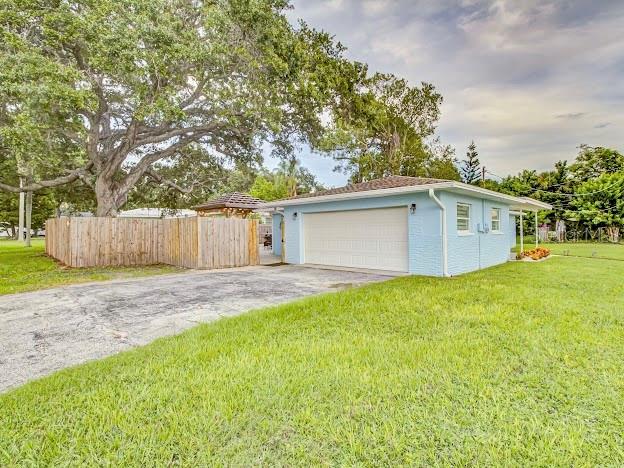A light blue detached garage sits on a grassy lot next to a wooden fence — 5151 DUHME ROAD, ST PETERSBURG, FL