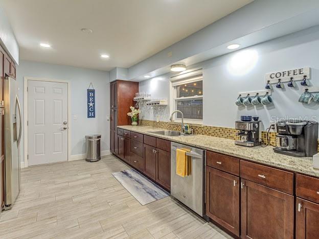 A kitchen features dark wood cabinets, stainless steel appliances, and light-colored tile flooring — 5151 DUHME ROAD, ST PETERSBURG, FL