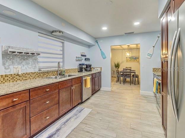 A kitchen with wood cabinets, granite countertops, and a dining area visible in the background — 5151 DUHME ROAD, ST PETERSBURG, FL