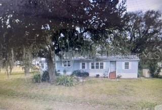 A light blue single-story house sits behind a large tree with hanging moss — 4545 WINDEE AVENUE, LAKELAND, FL