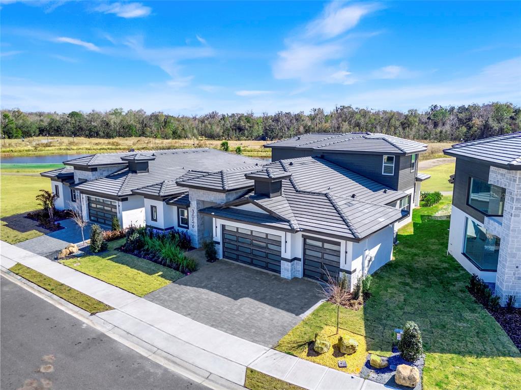 An aerial view of a modern house with a gray tile roof and three-car garage — 3056 KENSINGTON AVENUE, DAVENPORT, FL