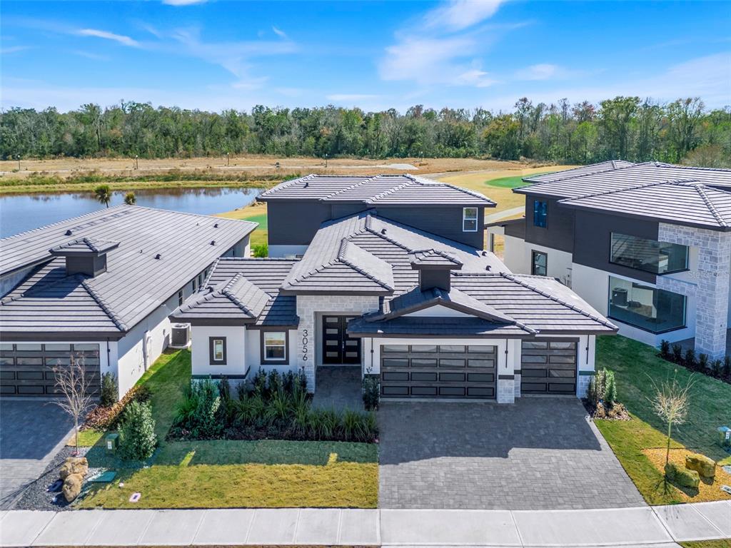 An aerial view of a modern house with a tiled roof and a paved driveway — 3056 KENSINGTON AVENUE, DAVENPORT, FL