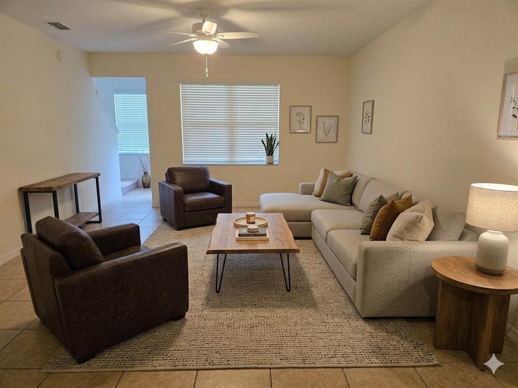 A living room features a sectional sofa, two leather armchairs, and a wooden coffee table — 3158 RODRICK CIRCLE UNIT 3158, ORLANDO, FL