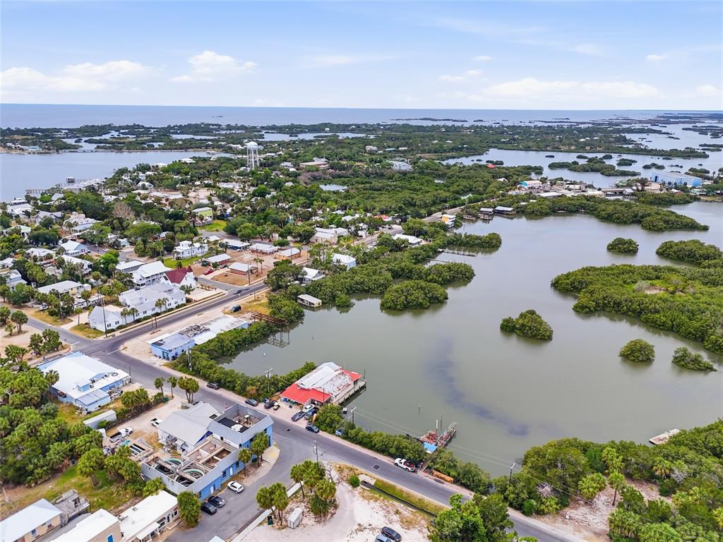 An aerial view shows a coastal town with buildings, roads, and surrounding mangrove islands — 505 3RD STREET, CEDAR KEY, FL