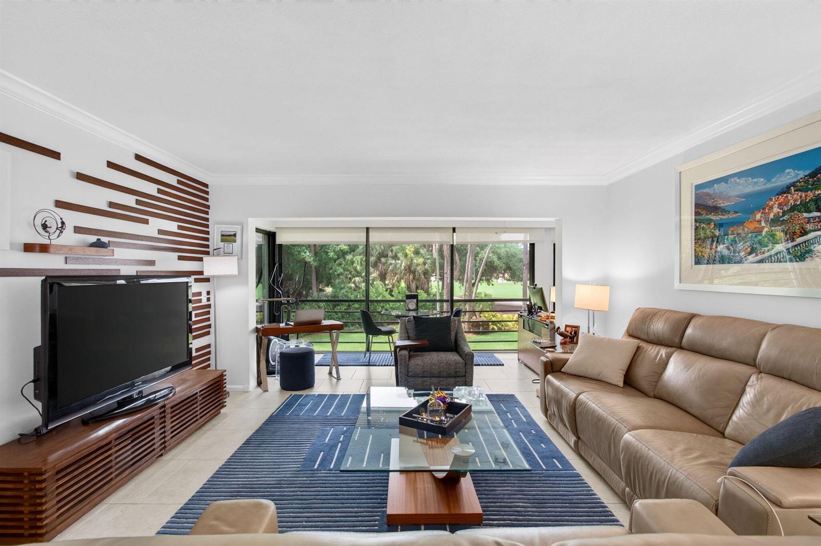 A living room features a tan leather sofa, a glass coffee table, and a slatted wall — 4084 N Quail Ridge Drive Unit B, Boynton Beach FL 33436, BOYNTON BEACH, FL