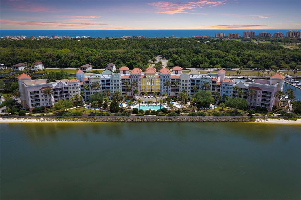 An aerial view of a large, multi-story waterfront resort complex with a central swimming pool — 102 YACHT HARBOR DRIVE UNIT 467, PALM COAST, FL