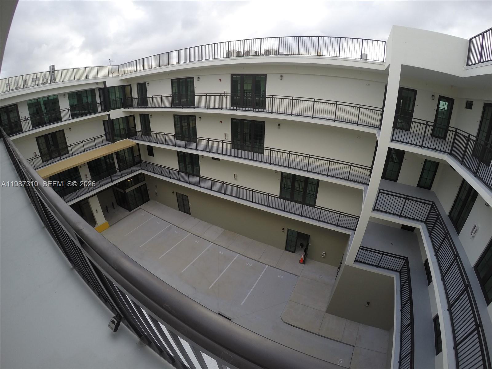 An elevated view shows the central courtyard and parking area of a multi-story apartment building — 4100 SW 64th Ave # 409, Davie FL 33314, DAVIE, FL