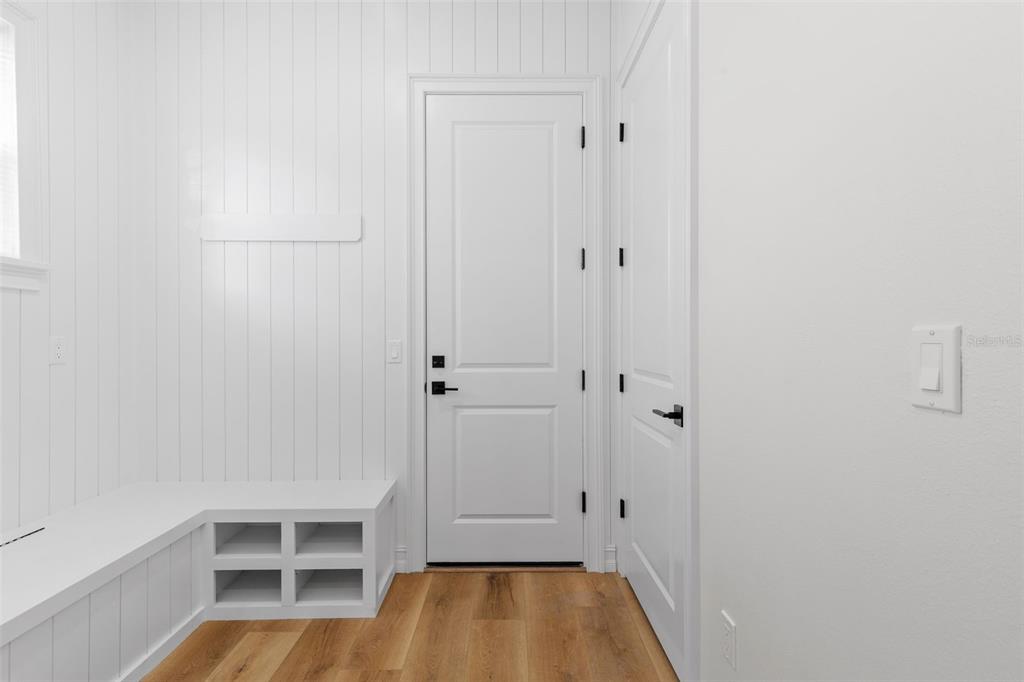 A mudroom features white shiplap walls, a built-in bench with cubbies, and wood flooring — 3801 71ST STREET N, ST PETERSBURG, FL