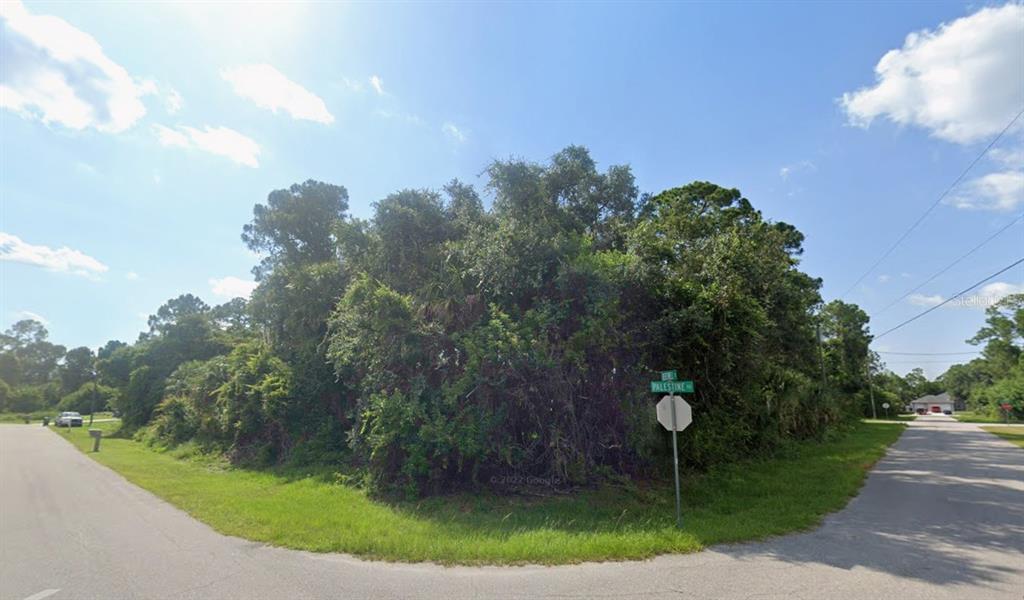 A vacant, heavily wooded corner lot sits at the intersection of two paved residential streets — Lot 12 BERTWELL STREET, NORTH PORT, FL