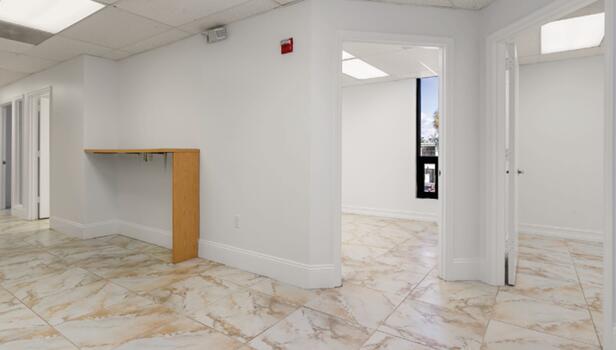 An office interior features white walls, marble-patterned tile floors, and a built-in wooden counter — 50 NE 26th Street, Pompano Beach FL 33064, POMPANO BEACH, FL