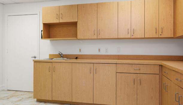 A kitchen or breakroom features light wood cabinets, a laminate countertop, and a stainless sink — 50 NE 26th Street, Pompano Beach FL 33064, POMPANO BEACH, FL