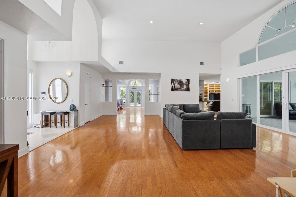 A spacious living room features high ceilings, hardwood floors, and a large grey sectional sofa — 8179 Lakeview Dr, West Palm Beach FL 33412, WEST PALM BEACH, FL