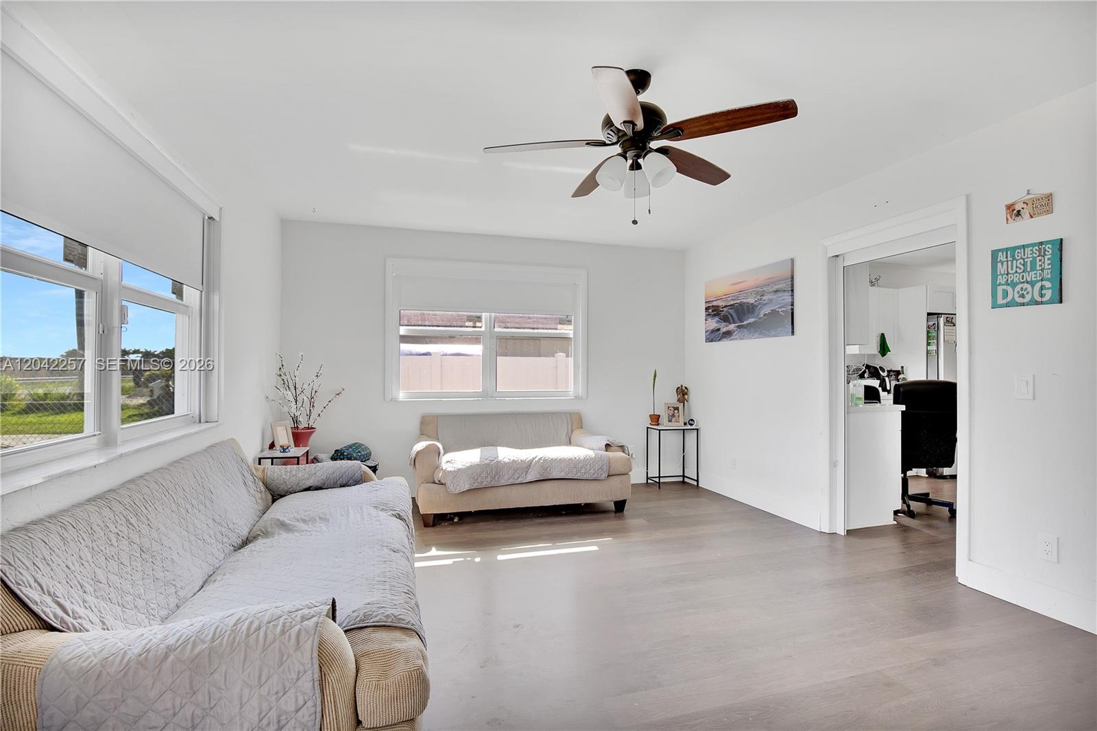 A living room features white walls, wood-look flooring, two sofas, and a ceiling fan — 11940 SW 212th St, Miami FL 33177, MIAMI, FL