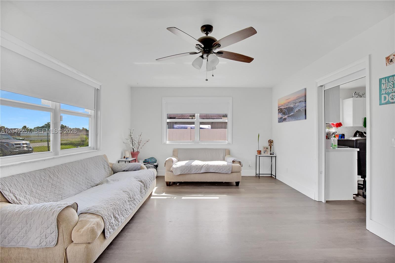 A living room features white walls, wood-look flooring, two sofas, and a ceiling fan — 11940 SW 212th St, Miami FL 33177, MIAMI, FL