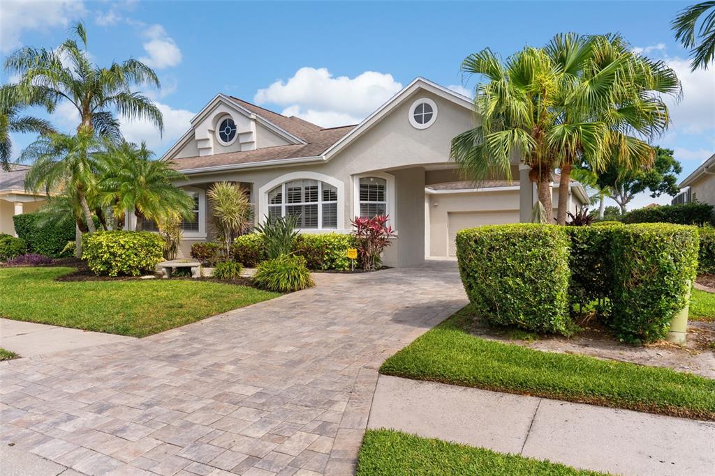 A single-story house with a paved driveway, palm trees, and a covered garage entrance — 4516 SWORDFISH DRIVE, BRADENTON, FL