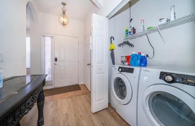A laundry area with a washer and dryer sits next to an entryway with a door — 1179 S BEACH CIRCLE, KISSIMMEE, FL