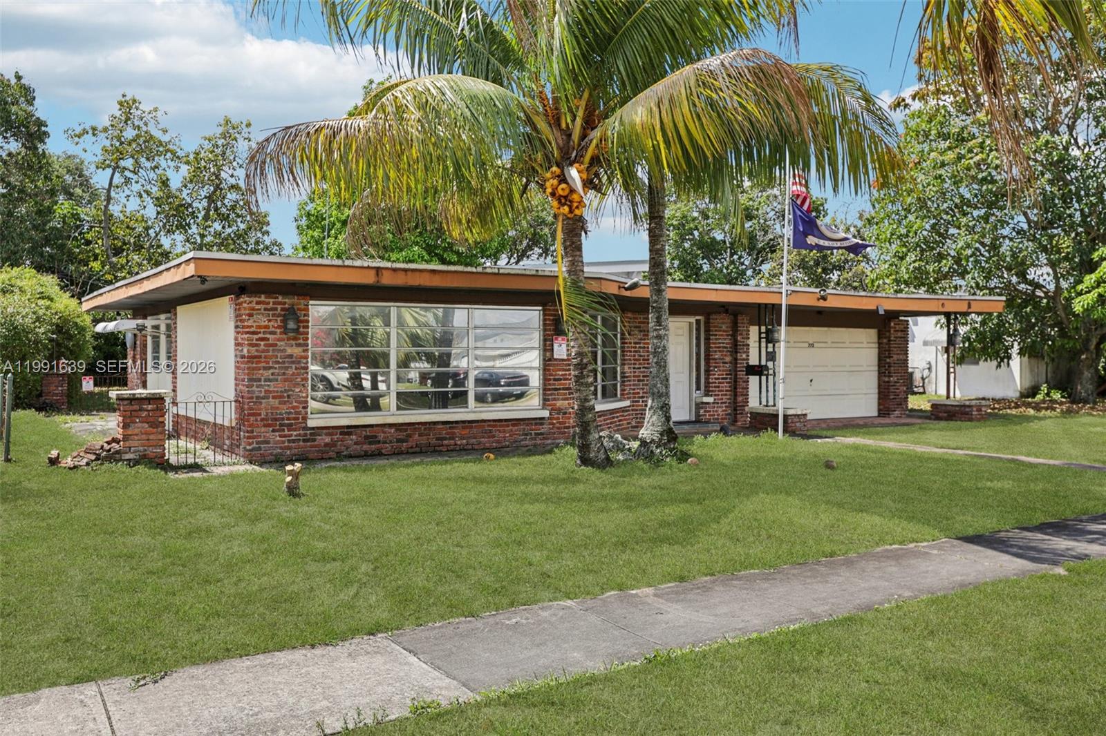 A single-story brick house features a flat roof, large windows, and a palm tree — 272 W 46th St, Hialeah FL 33012, HIALEAH, FL