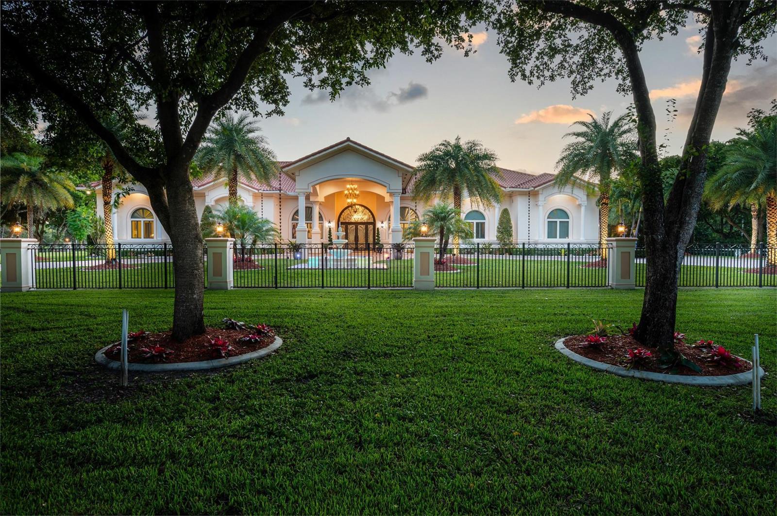 A large, single-story estate with a gated lawn, palm trees, and a central arched entrance — 5801 Estates Drive, Southwest Ranches FL 33330, SOUTHWEST RANCHES, FL