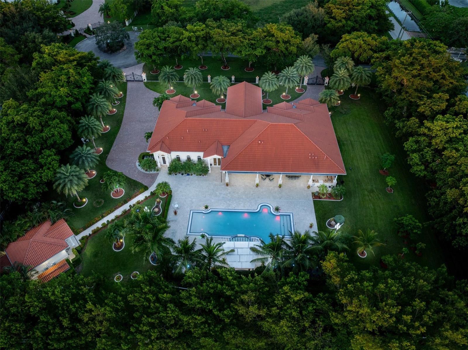 An aerial view of a house with a red tile roof, pool, and surrounding trees — 5801 Estates Drive, Southwest Ranches FL 33330, SOUTHWEST RANCHES, FL