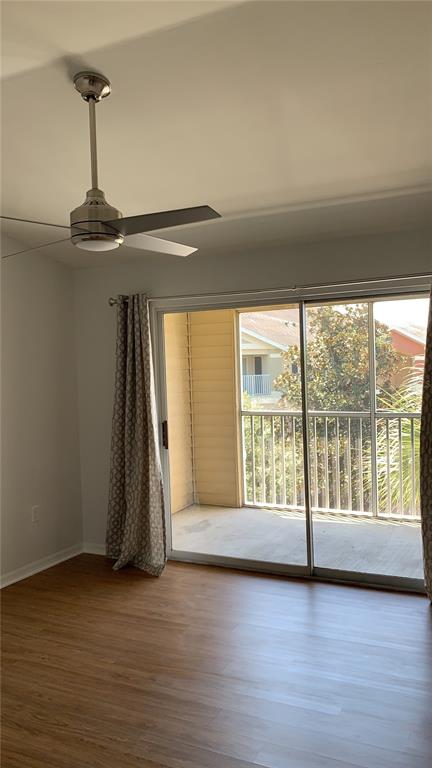 A room with wood-look flooring, a ceiling fan, and a sliding glass door to a balcony — 1949 SUMMER CLUB DRIVE UNIT 311, OVIEDO, FL