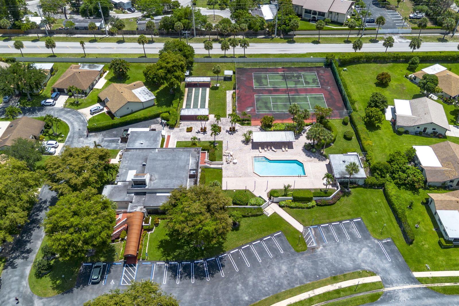An aerial view shows a community clubhouse with a swimming pool and tennis courts — 6320 Lakemont Circle, FL 33463, FL