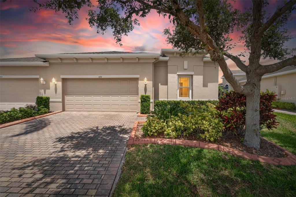 A single-story house exterior features a paved driveway, a two-car garage, and landscaped front yard — 642 CHIPPER DRIVE, SUN CITY CENTER, FL