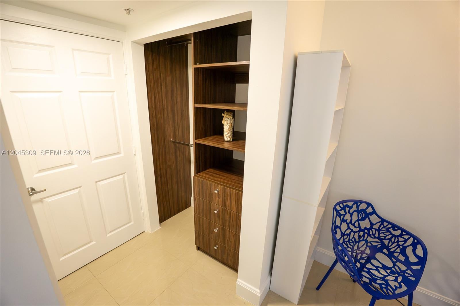 A laundry closet with a stacked washer-dryer sits adjacent to a small bathroom with a shower — 2951 S Bayshore Dr # 716, Miami FL 33133, MIAMI, FL