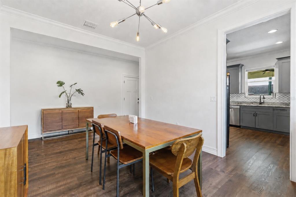 A dining room with a wooden table and chairs sits adjacent to a gray kitchen — 2510 W CARMEN STREET, TAMPA, FL