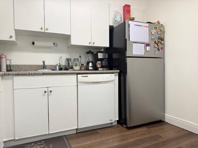 A kitchen features white cabinets, a dishwasher, a stainless steel refrigerator, and a dark countertop — 5201 NW Geneva Way # 103, Doral FL 33166, DORAL, FL