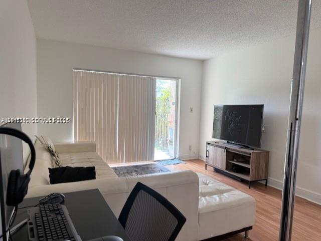 A living room features a white sectional sofa, a television on a stand, and blinds — 5201 NW Geneva Way # 103, Doral FL 33166, DORAL, FL