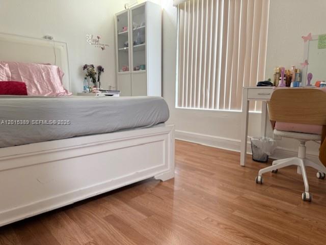 A bedroom features a white bed frame, a tall glass-front cabinet, and a vanity desk — 5201 NW Geneva Way # 103, Doral FL 33166, DORAL, FL