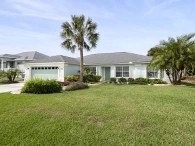 A single-story house with a light-colored exterior, a two-car garage, and two palm trees — 19 MAHOE DRIVE N, PALM COAST, FL