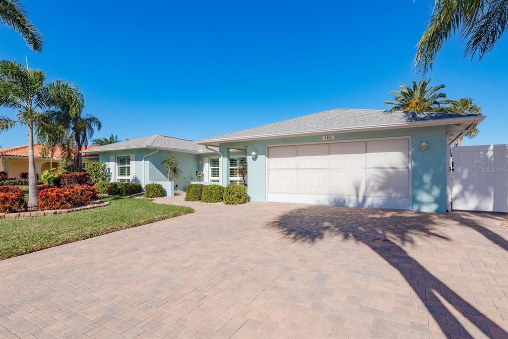 A light blue single-story house features a paved driveway, a two-car garage, and palm trees — 3301 SEAWAY DRIVE, NEW PORT RICHEY, FL