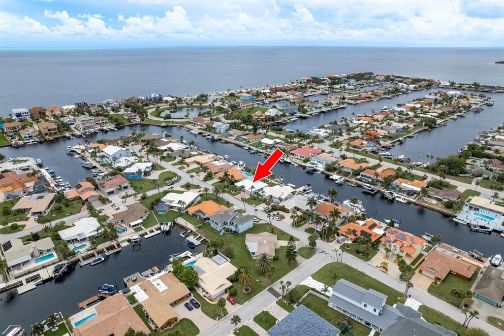 An aerial view shows a residential neighborhood with houses situated along interconnected canals — 3301 SEAWAY DRIVE, NEW PORT RICHEY, FL