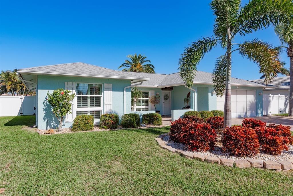A light blue single-story house features a front lawn, palm trees, and a two-car garage — 3301 SEAWAY DRIVE, NEW PORT RICHEY, FL