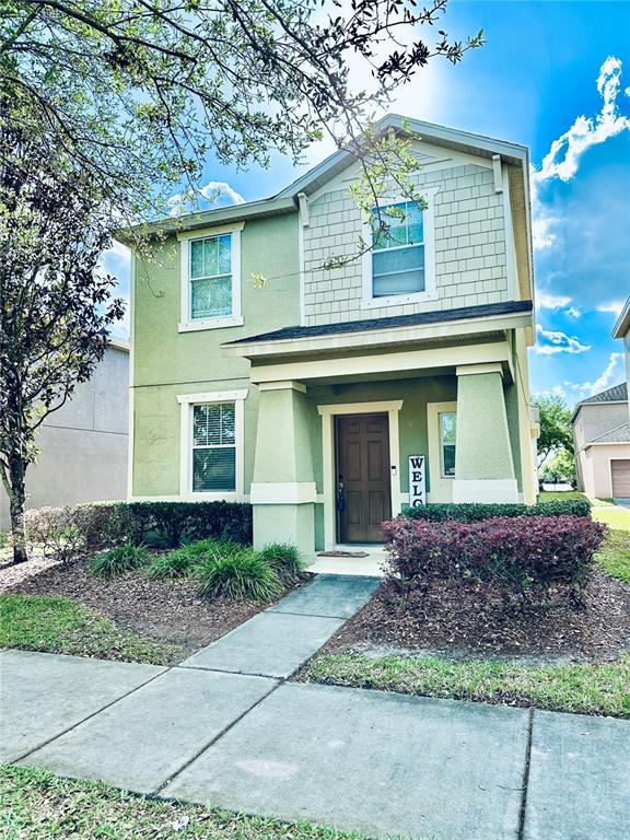 A two-story house with light green siding and a covered front porch entrance — 4411 BANYAN TREE PLACE, RIVERVIEW, FL