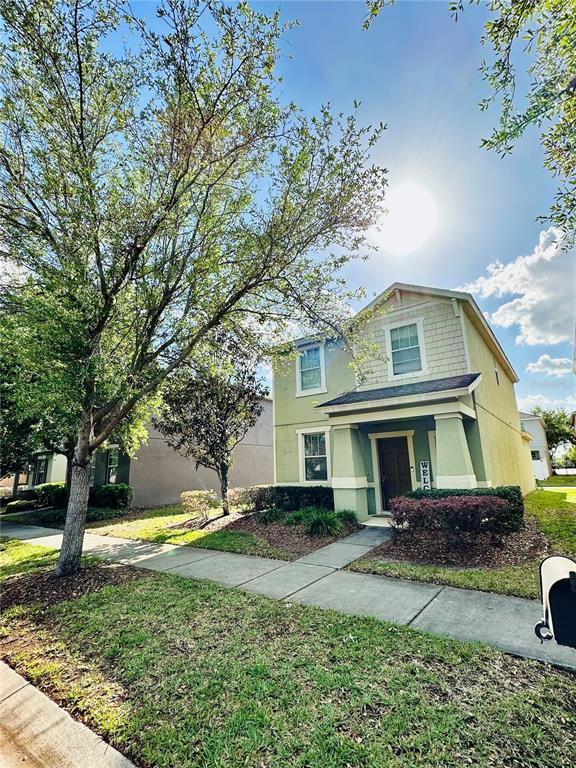 A two-story house with light green siding and a covered front porch stands outdoors — 4411 BANYAN TREE PLACE, RIVERVIEW, FL