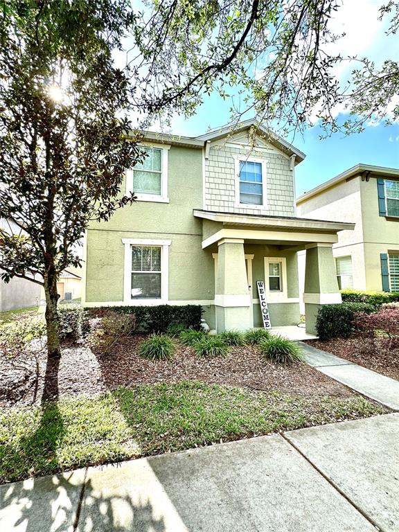 A two-story house with light green stucco siding and a covered front porch — 4411 BANYAN TREE PLACE, RIVERVIEW, FL