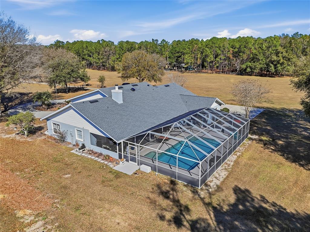 An aerial view of a house with a screened-in pool and a large grassy yard — 9115 NW 170TH STREET, ALACHUA, FL