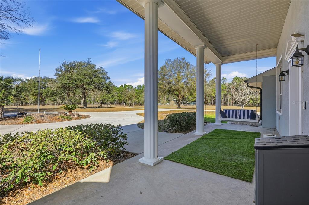 A single-story house with a covered front porch and a concrete driveway — 9115 NW 170TH STREET, ALACHUA, FL